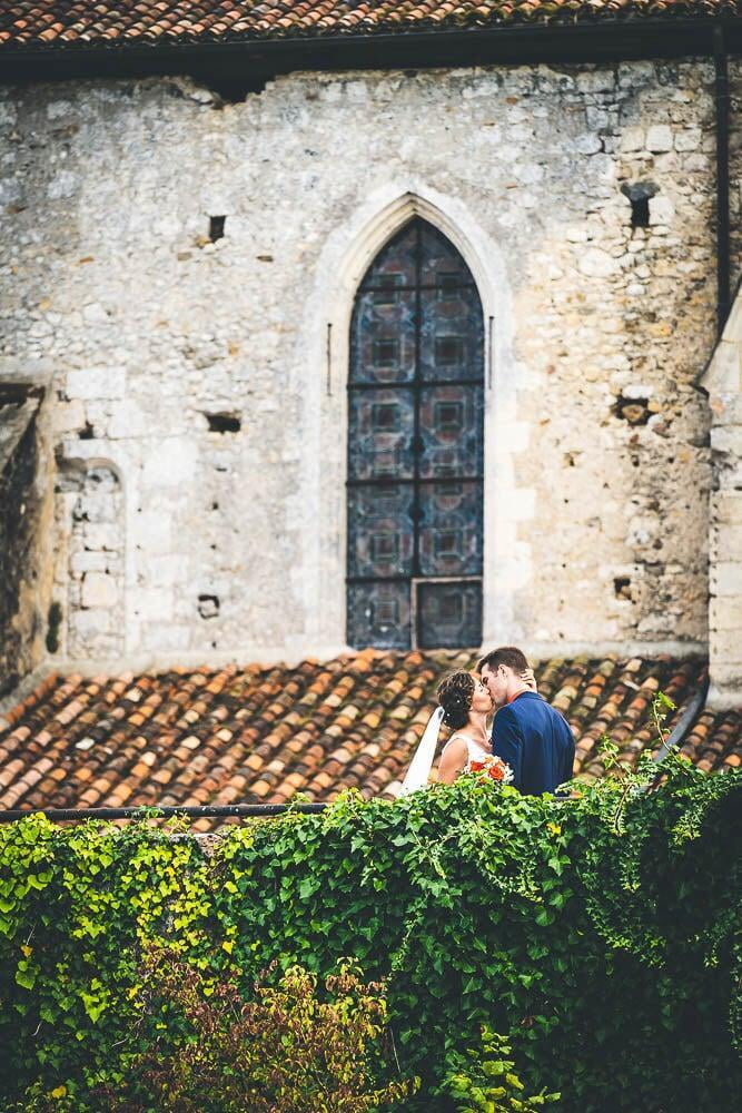 Jeune mariés s'embrassent devant l'église après le mariage
