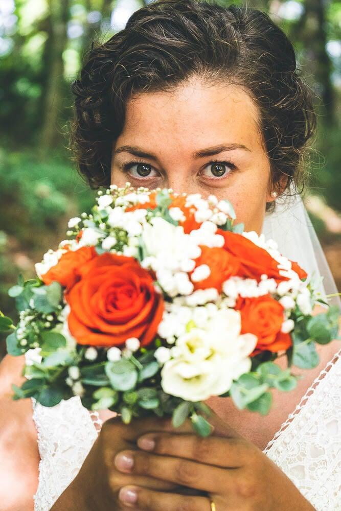 Femme mariés montre son bouquer rouge et blanc 