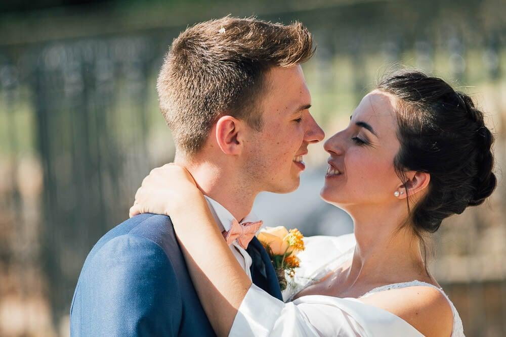 Mariée et marié s'embrasse devant l'église du mariage en bourgogne 